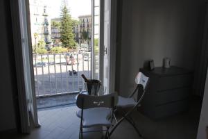 ナポリにあるBase Napoli Mergellinaのテーブルと椅子、窓が備わる客室です。