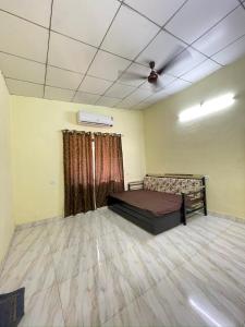 a room with a bed and a ceiling fan at Royal villa in Thane