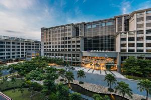大園区にあるHyatt Regency Taoyuan International Airportのヤシの木が植えられた大きな建物の空中風景
