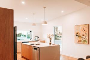 a kitchen with a refrigerator and a counter top at Blanca Beach House in Weymouth
