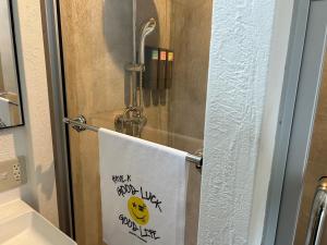 ein Handtuch, das an einer Duschtür im Bad hängt in der Unterkunft グッドラックスタービーチ in Hamada