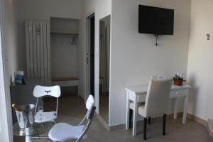 ナポリにあるBase Napoli Mergellinaのテーブルと椅子、テレビが備わる客室です。