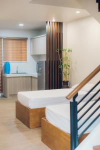 two beds in a room with a kitchen at Elyseah Condotel, Angeles Pampanga in Angeles