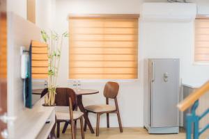 a kitchen with a table and chairs and a refrigerator at Elyseah Condotel, Angeles Pampanga in Angeles