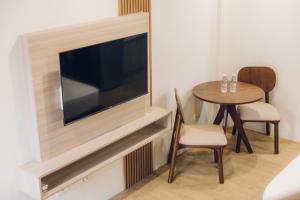 a living room with a flat screen tv and a table at Elyseah Condotel, Angeles Pampanga in Angeles