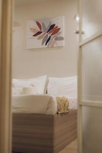 a bedroom with a bed with white sheets and a painting at Elyseah Condotel, Angeles Pampanga in Angeles +11 photos