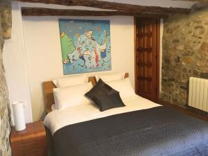 a bedroom with a bed with a painting on the wall at Finca Seguró in Sella