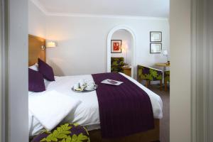a hotel room with a bed with a tray on it at The Chequers Hotel in Newbury