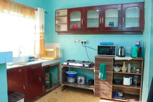 a kitchen with a sink and a microwave at Adorable Homely Stay in Nakuru