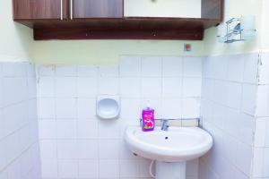 a bathroom with a sink and a soap dispenser at Adorable Homely Stay in Nakuru +14 photos