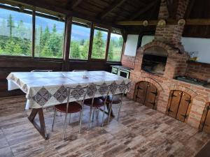 a kitchen with a table and a brick oven at Cabana Busuioc in Colibiţa