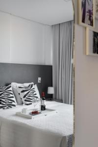 a white bed with a tray of food on it at Feel Home - Flat Romântico com Piscina no Rooftop in Cabedelo