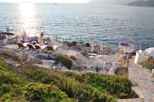 a group of chairs sitting on a beach next to the water at Lukka Exclusive Hotel – Adult Only +12 in Kaş