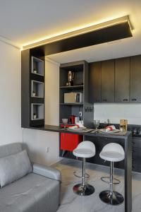 a living room with a couch and a kitchen at Feel Home - Flat Romântico com Piscina no Rooftop in Cabedelo