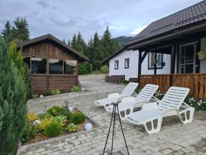 - un ensemble de chaises blanches assises sur une terrasse dans l'établissement Cabana Busuioc, à Colibiţa