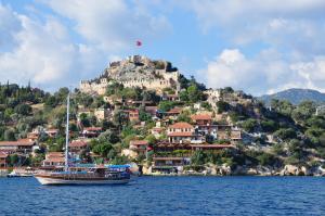 a boat in the water in front of a mountain at Lukka Exclusive Hotel – Adult Only +12 in Kaş