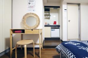 a bedroom with a desk and a bed and a mirror at Nogata House in Tokyo