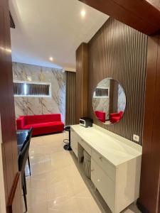 a living room with a red couch and a mirror at Gets Hotel in Malang