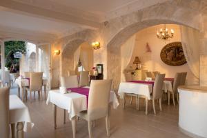 a restaurant with white tables and chairs and a chandelier at Lukka Exclusive Hotel – Adult Only +12 in Kaş
