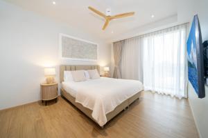 a bedroom with a bed and a ceiling fan at Laguna Beachside Residents in Phuket