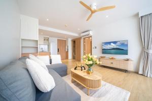 a living room with a blue couch and a table at Laguna Beachside Residents in Phuket