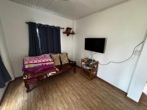 a living room with a couch and a tv in a room at บ้านเขาค้อคุณย่า in Khao Kho