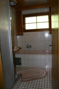 ein Badezimmer mit einer Badewanne und einem Waschbecken in der Unterkunft Gästehaus Struggl in Steindorf am Ossiacher See
