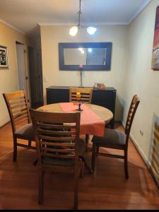a dining room with a table and four chairs at Departamento centrico en la serena para 5-6 personas a 3 minutos de la playa in La Serena
