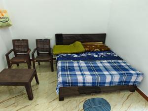 una camera da letto con un letto e due sedie di Float View Home stay a Gorakhpur