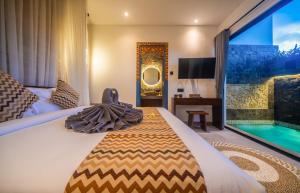 a hotel room with a bed and a swimming pool at 3Bedroom - 703 - Private Pool Villa Sanur in Sanur +54 photos