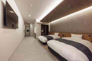 una camera da letto con due letti e una TV a schermo piatto di 南紀月の瀬温泉ぼたん荘 a Takaike