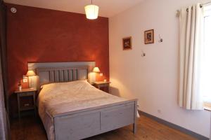 a bedroom with a large bed and two tables with lamps at La Grange des Griottiers in Saint-Priest