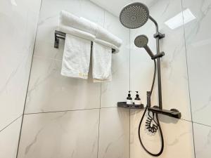 a shower in a bathroom with white tiles at Banyueli Hotel in Shanghai +53 photos
