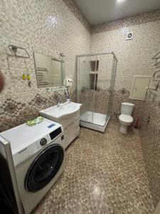 a bathroom with a sink and a washing machine at MEGAPOLIS Yunusabad in Darkhon +4 photos