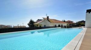 a large swimming pool in front of a house at CANELAS PREMIUM NUEVOS con PISCINA, AMPLIAS TERRAZAS Y GARAJE in Portonovo