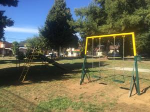a playground with a swing set in a park at Tribu Malen Apartamentos in Temuco