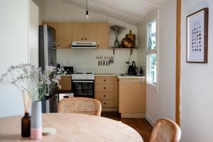 a kitchen with a table and chairs and a kitchen with a refrigerator at Gunuma Shack in Mount Beauty