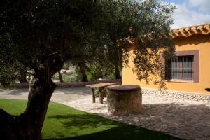 a picnic bench under a tree next to a building at El Mirador de Gebas in Alhama de Murcia