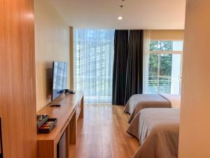 a hotel room with two beds and a television at The Kaset, Hua Hin in Hua Hin