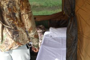 a person standing next to a bed in a tent at Gal Oya Camping in Inginiyagala
