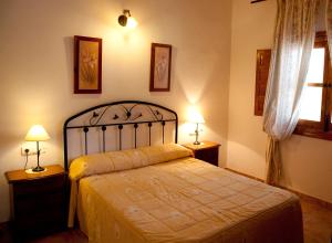 een slaapkamer met een bed met 2 lampen en een raam bij El Mirador de Gebas in Alhama de Murcia