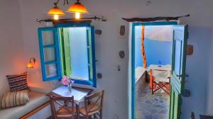 a room with two windows and a table and chairs at Pano Gitonia in Aegiali
