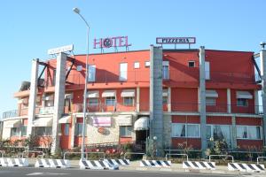 un hotel rosso con un cartello hotel sopra di Hotel Nuova Orchidea a Dresano