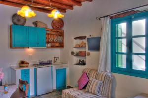 a kitchen with blue cabinets and a chair in a room at Pano Gitonia in Aegiali