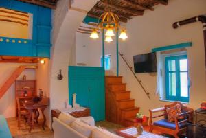 a living room with a blue door and stairs at Pano Gitonia in Aegiali
