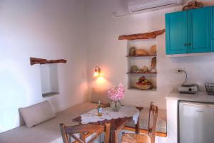 a kitchen with a table and chairs and blue cabinets at Pano Gitonia in Aegiali