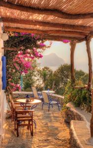 a patio with a table and chairs and flowers at Pano Gitonia in Aegiali