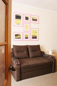 a brown couch in a room with pictures on the wall at VitaPark Solnechniy Provans in Satanov
