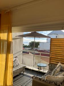 a patio with a table and an umbrella on a balcony at brin de mer in Saint-Pierre
