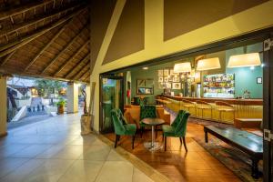 a restaurant with green chairs and a table and a bar at First Group Sanbonani Resort in Hazyview